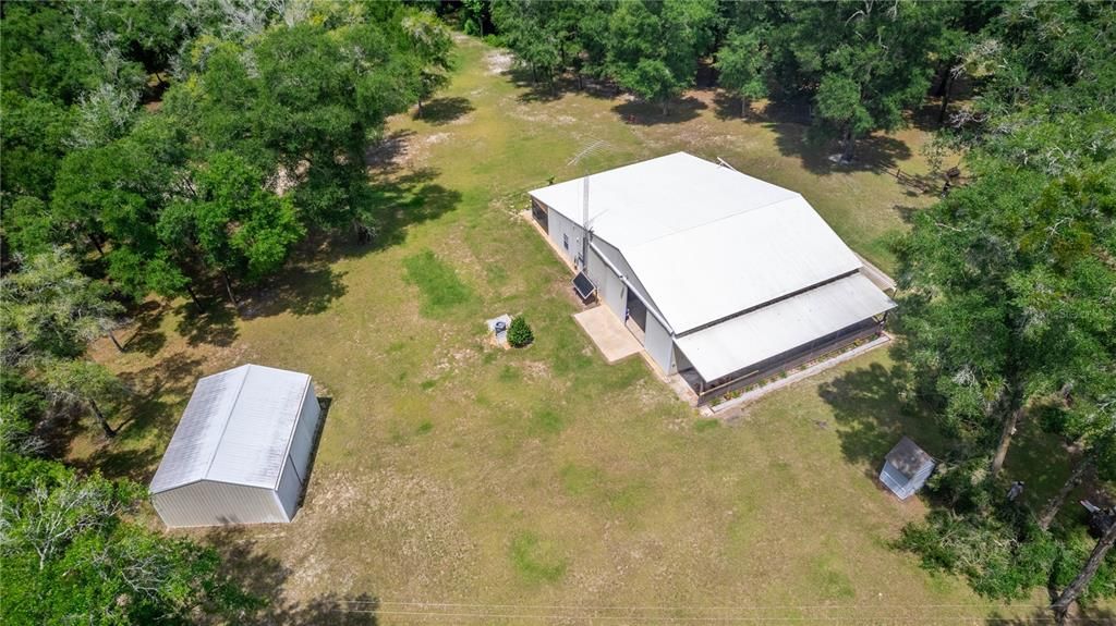 Aerial looking at backside of hangar and outdoor RV port on the right side of the hangar.