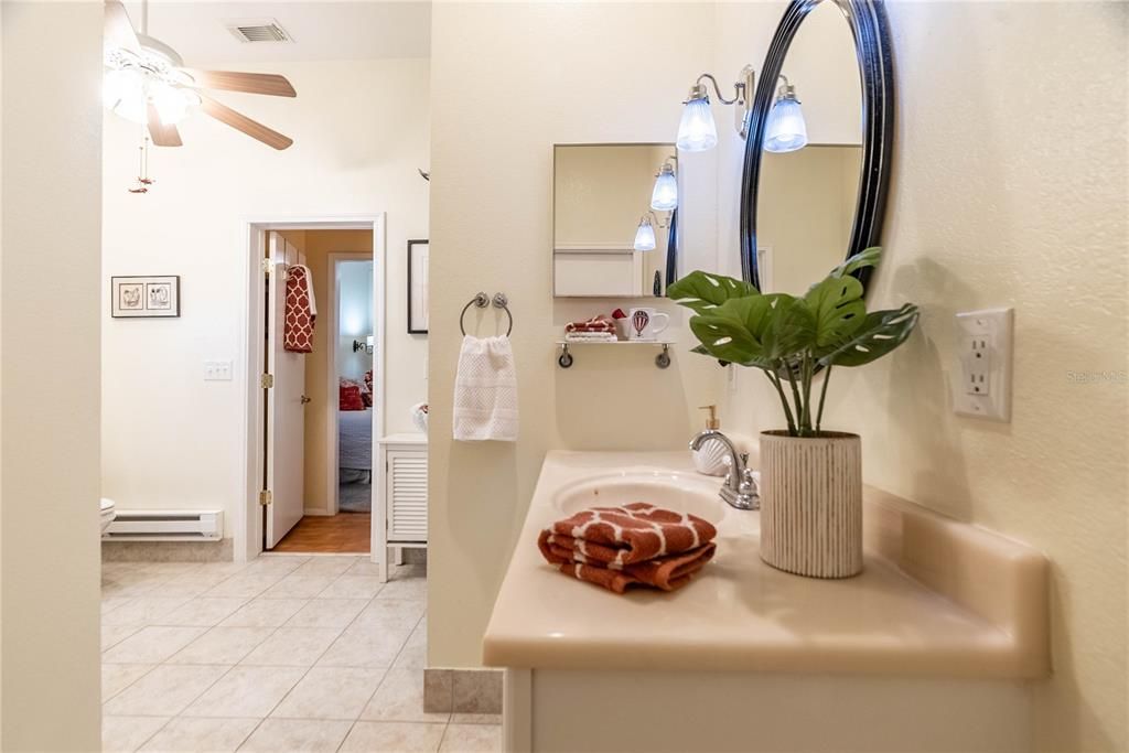 Bathroom features a ceiling fan and light kit for circulation.