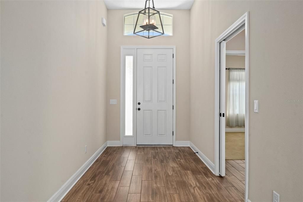 The entry hall gives you a peek of what awaits you, with the wood-like ceramic plank tile. The guest suite area is entered via the doorway to the right. Notice the pocket door, that allows guests to create their own guest quarters for privacy between bedroom and bathroom.