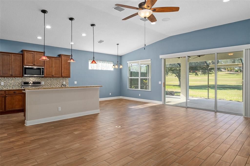 This view is from the doorway of the 2nd primary bedroom/den/office, toward the kitchen and the dining area in the back corner.