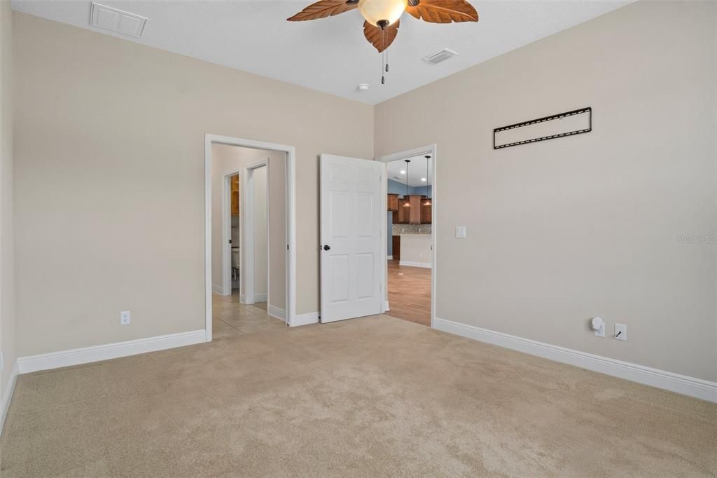 Opposite view of first primary bedroom looking across into primary bath. The doorway right of center leads back into the great room.