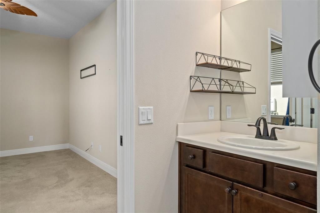 The primary bath features 2 separate comfort height vanities and 2 walk-in closets. This is a view looking into the 2nd primary bedroom/den/office.