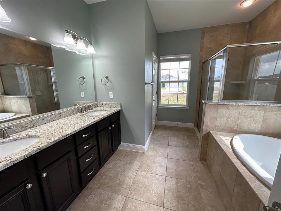 Master bathroom with double sink vanity, tub, shower and water closet