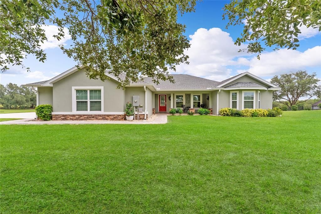 FRONT EXTERIOR view shows home perched on a hill in center of 4.75 ACRE plot.