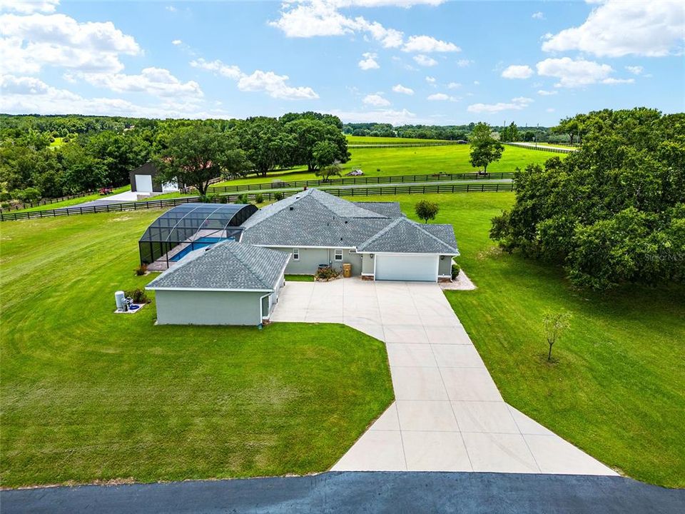 View looking SOUTH shows rolling terrain of area & large CONCRETE DRIVEWAY