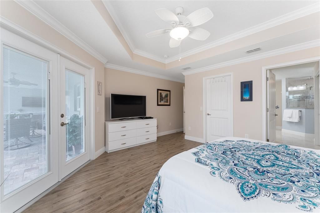 PRIMARY/MASTER BEDROOM features FRENCH DOORS to covered LANAI & SWIMMING POOL ENCLOSURE