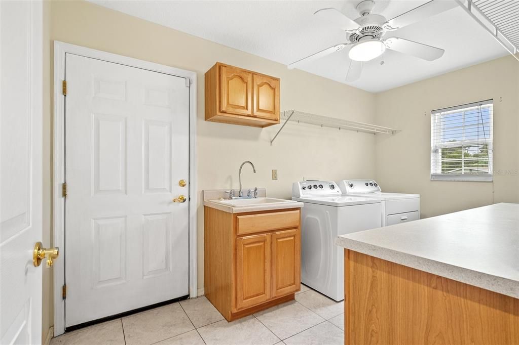 Spacious laundry area featuring abundant cabinet and countertop room.
