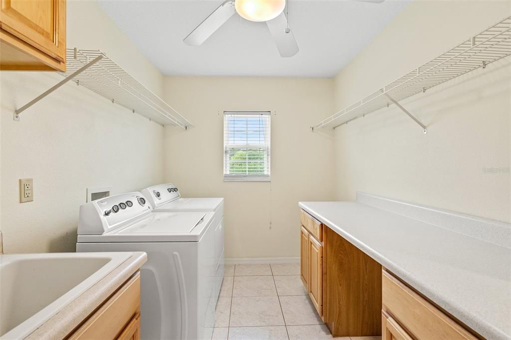 Spacious laundry area featuring abundant cabinet and countertop room.