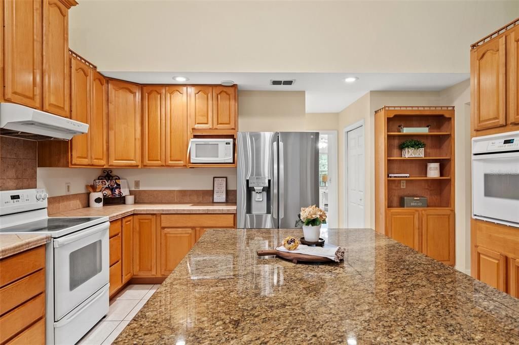 The kitchen area is designed with an open concept, allowing for a seamless view of the pool area through large sliding glass doors.