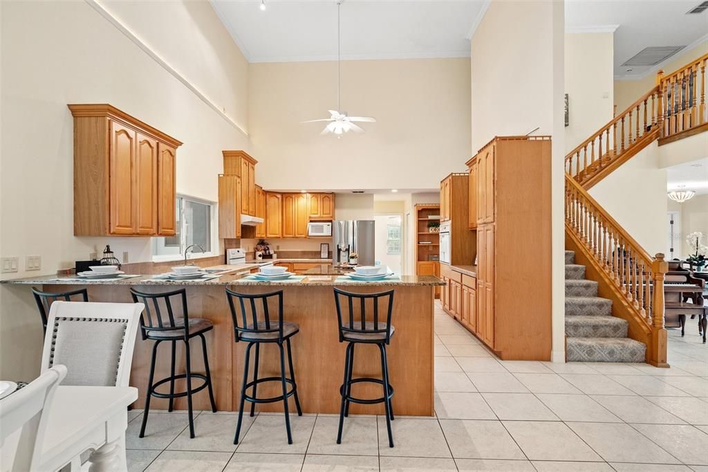 The kitchen features a spacious island, adorned with solid wood pine cabinets. The abundant cabinet space allows for ample storage, and there is also a designated bar area for added convenience.