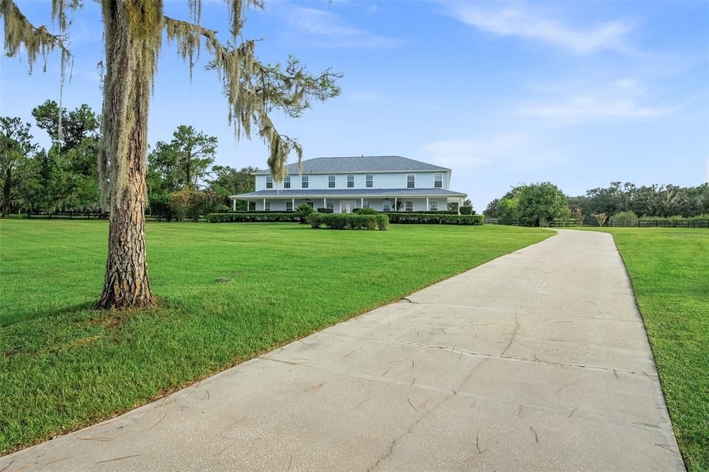 As you drive along the elongated driveway, you can't help but be captivated by the beautifully landscaped surroundings. The path leads you to a breathtaking 7,000 square foot home that leaves you in awe.