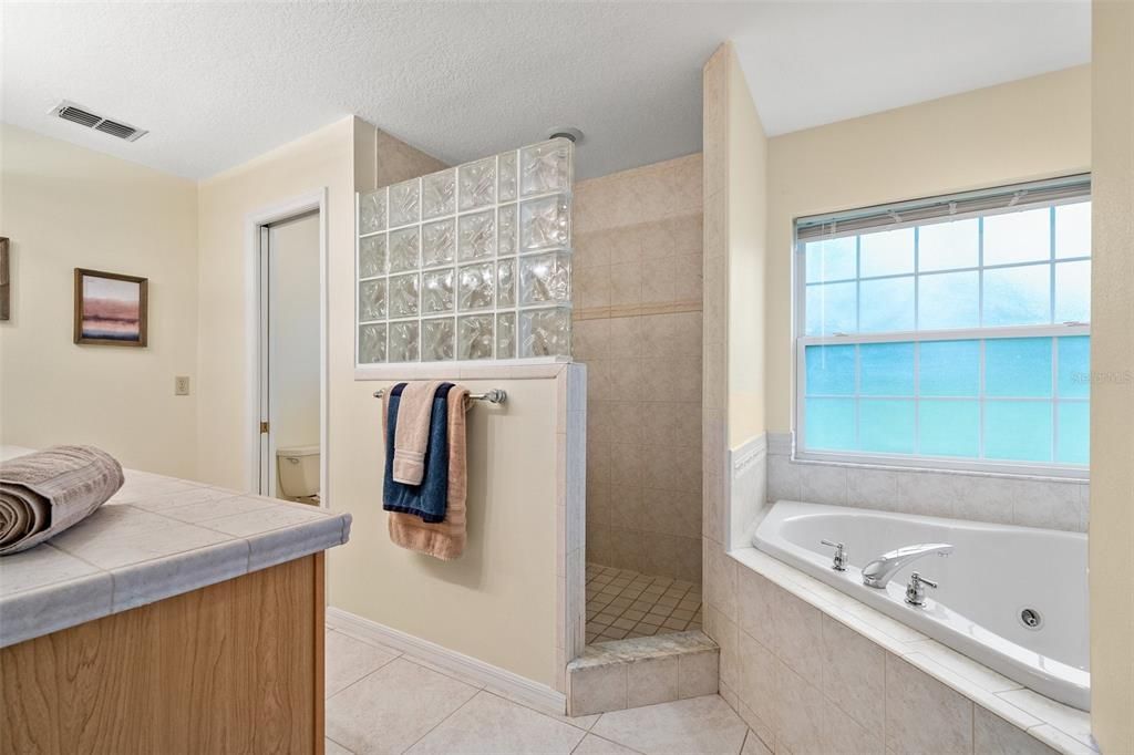 Spacious upstairs owner's suite featuring a luxurious bathroom complete with a Jacuzzi tub and a separate standing shower.