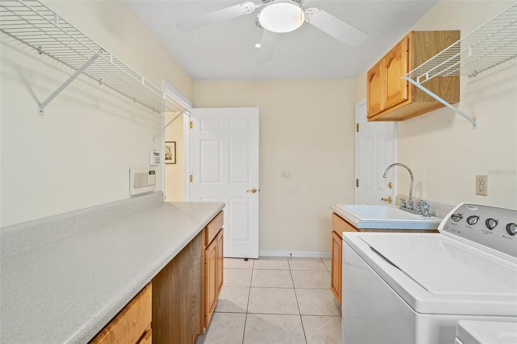 Spacious laundry area featuring abundant cabinet and countertop room.