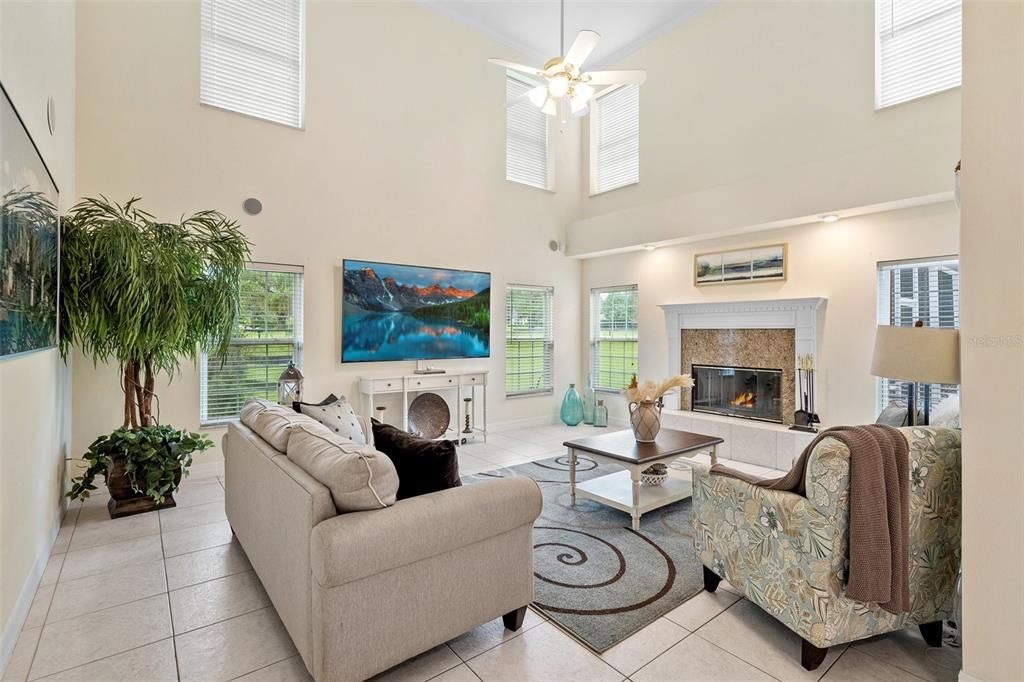 The family room is adorned with abundant natural light, thanks to its large windows and soaring ceilings. It boasts a generous space, providing ample room for everyone to relax and unwind. The centerpiece of the room is a charming fireplace, adding a warm and cozy ambiance to the entire space.