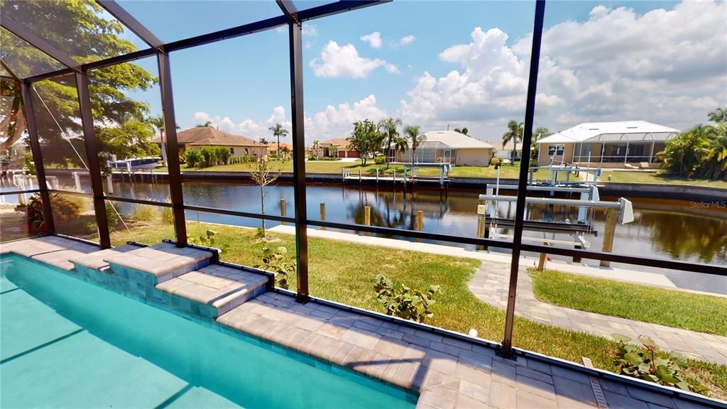 Screened pool enclosure and waterfront view of dock