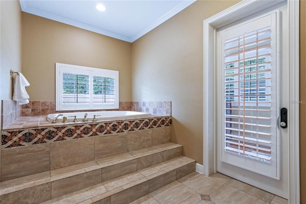 Dual water closets are located before entering the bath area, with door leading to the sunroom