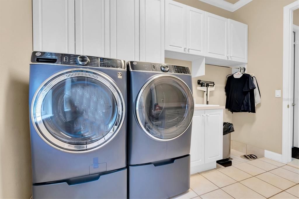 INSIDE LAUNDRY WITH CABINETS, SINK & IRONING BOARD