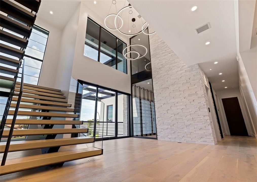 Custom Floating Stairs by Modulo designs with foyer measuring over 22 feet tall.