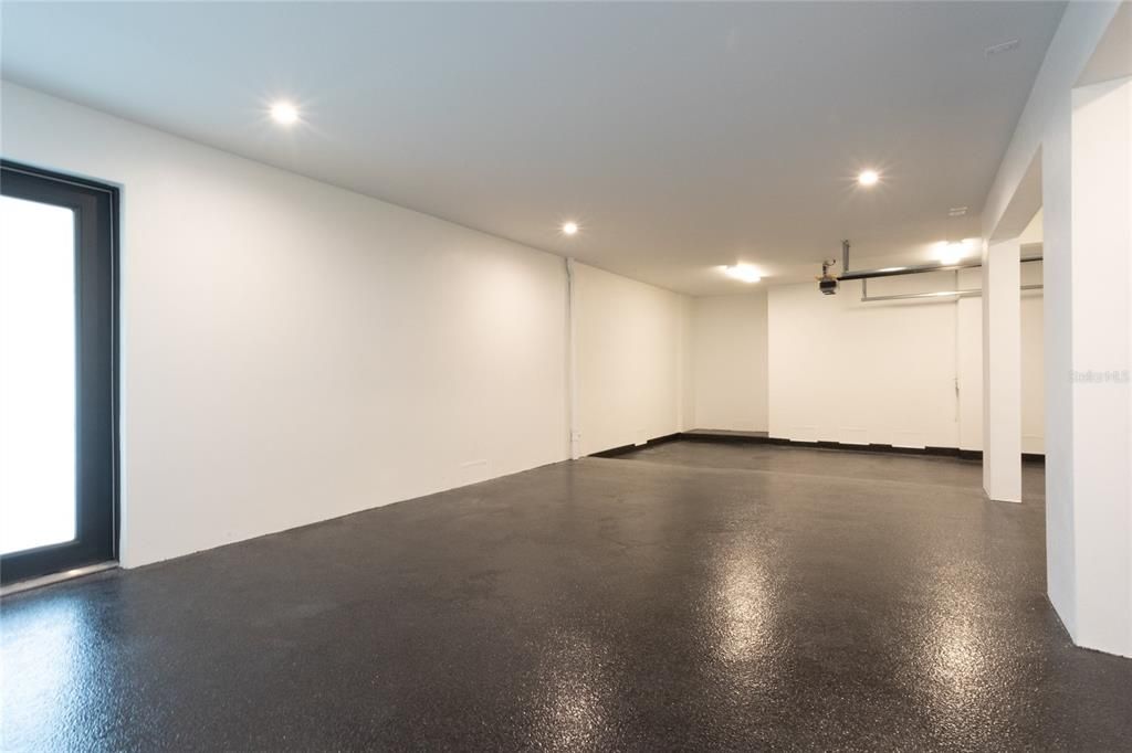 Garage with epoxy flooring featuring two work stations and large area perfect for a Golf Simulator or storing toys.