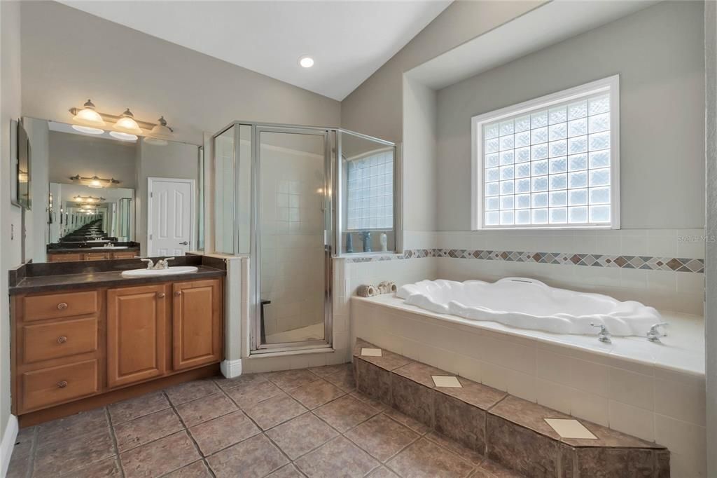 Master bath with dual vanities, vaulted ceilings, relaxing tub and separate shower.