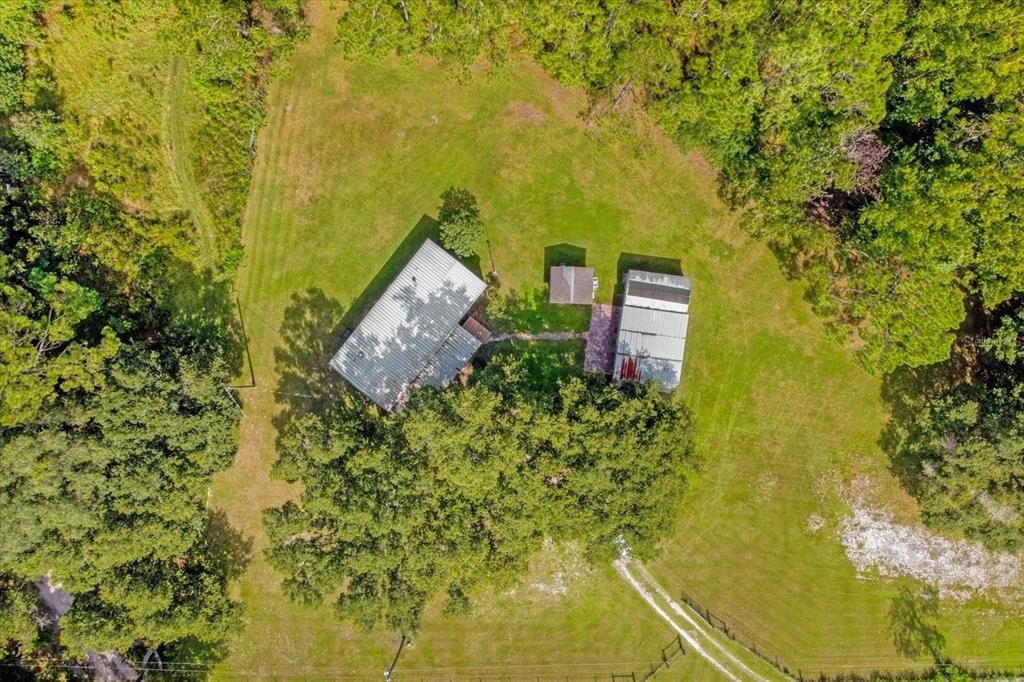 The 5 acres include all the land from the road, the land behind the home all the way back to the neighbors. The driveway is owned by the Seller and maintained by all the neighbors.