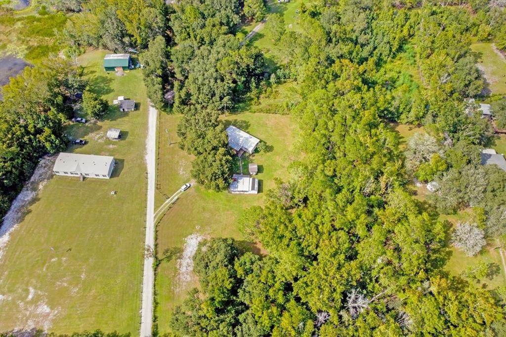The 5 acres include all the land from the road, the land behind the home all the way back to the neighbors. The driveway is owned by the Seller and maintained by all the neighbors.