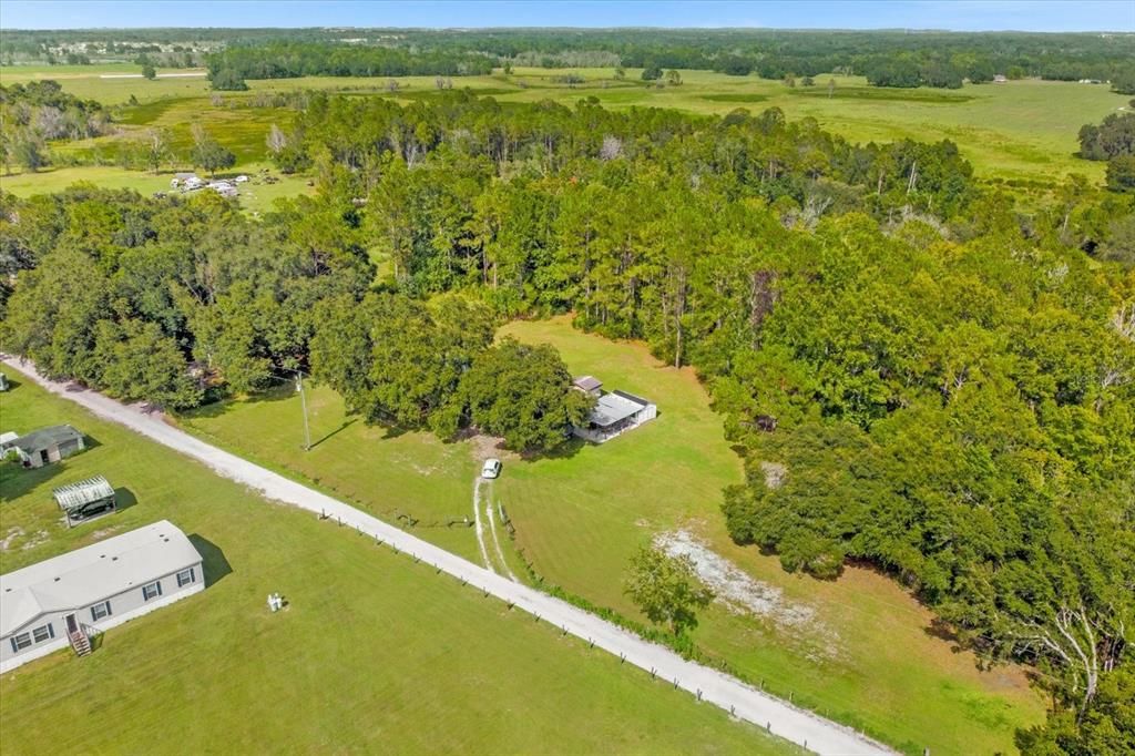 The 5 acres include all the land from the road, the land behind the home all the way back to the neighbors. The driveway is owned by the Seller and maintained by all the neighbors.