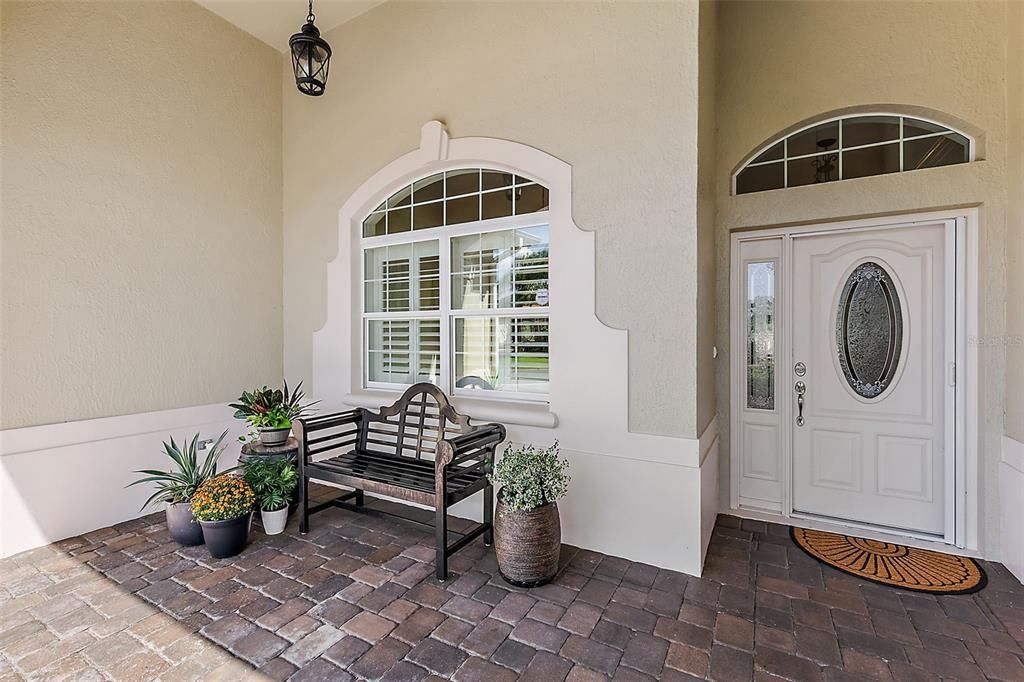 Covered front entrance w/elegant leaded glass accented door