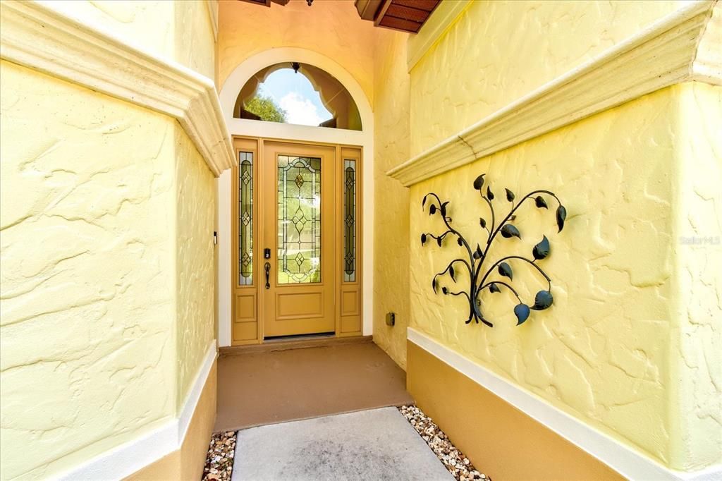 The Leaded Glass Door With Arched Window Above Make for a Spectacular Entrance. Architectural Design Features Appear Both Inside and Outside the Home