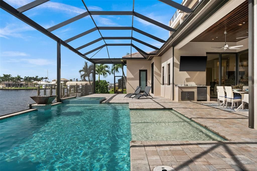 Large patio area with pool, spa, sun shelf and water/fire bowls.