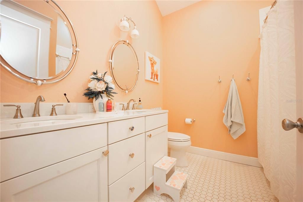 Upstairs guest bathroom with dual sinks