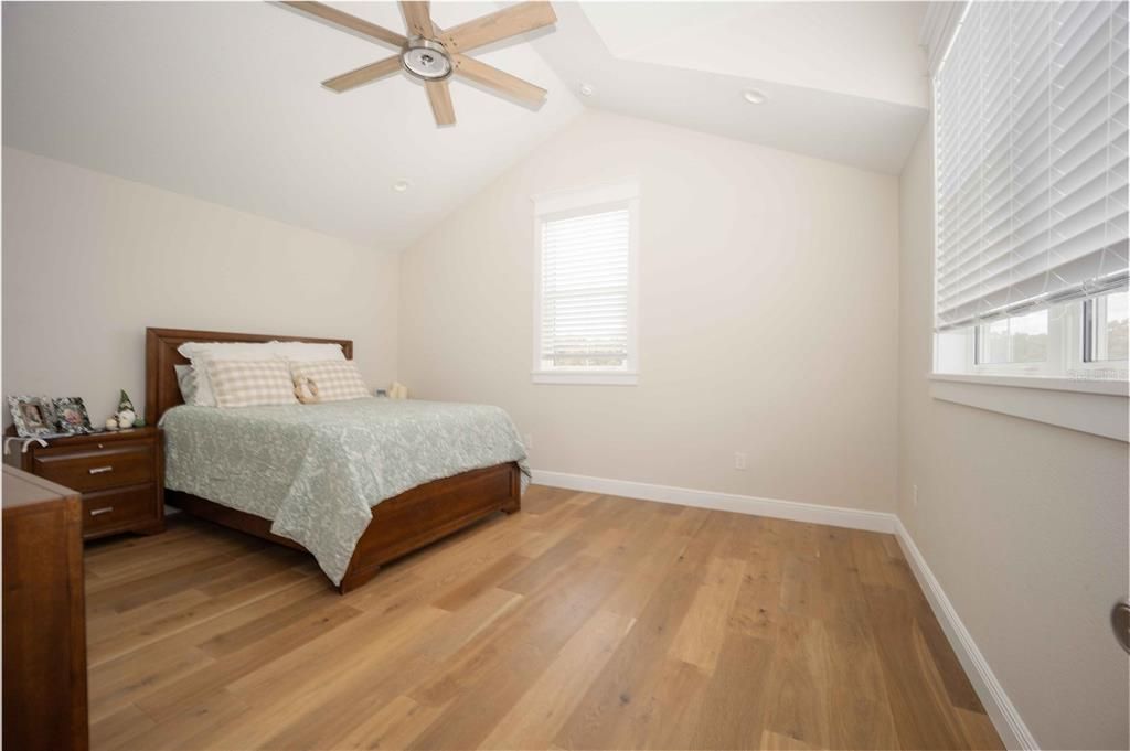 Spacious Guest Bedroom with wood floors and walk-in closet