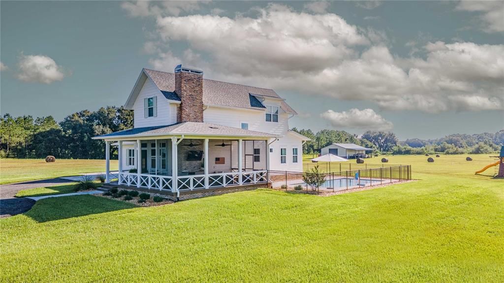 Side view of home with screened in porch and view of saltwater pool