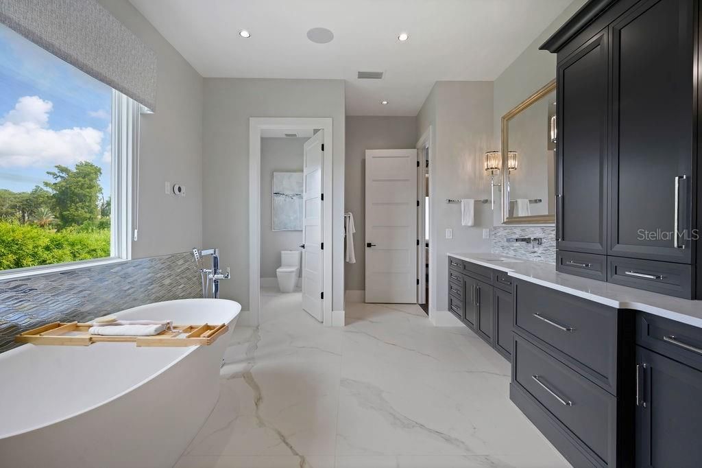Second master bath is soooooo spacious with generous soaking tub, private water closet and expanded vanity with custom cabinetry full of storage, drawers and double sinks for private prep time.