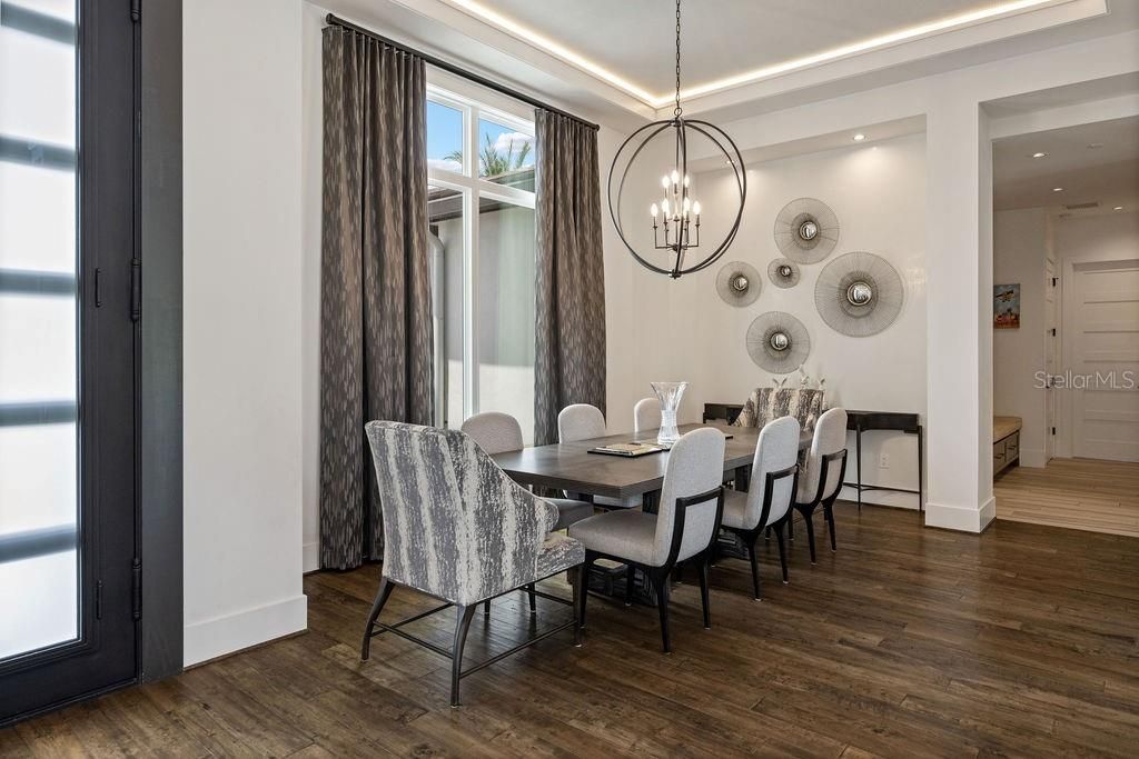 Through the dining area to the hallway which provides access to the laundry room and straight ahead the door beyond the bench seat is access to a first floor guest suite with en suite full bathroom.