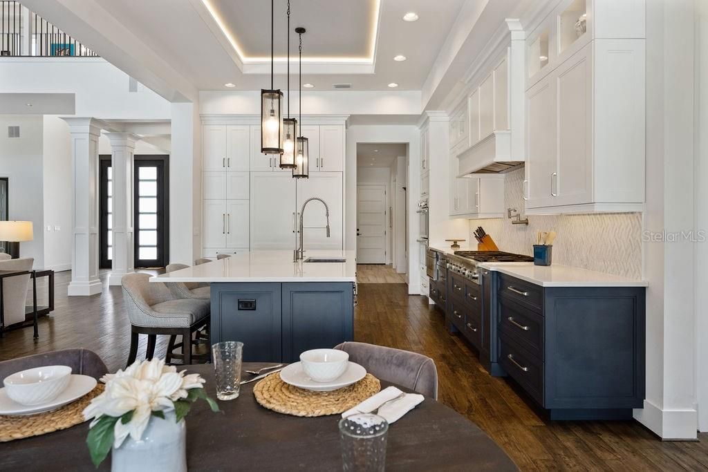 View from breakfast nook back into kitchen. Note the floor to ceiling cabinetry, crown molding, tray ceiling and engineered wood floors throughout lower level.