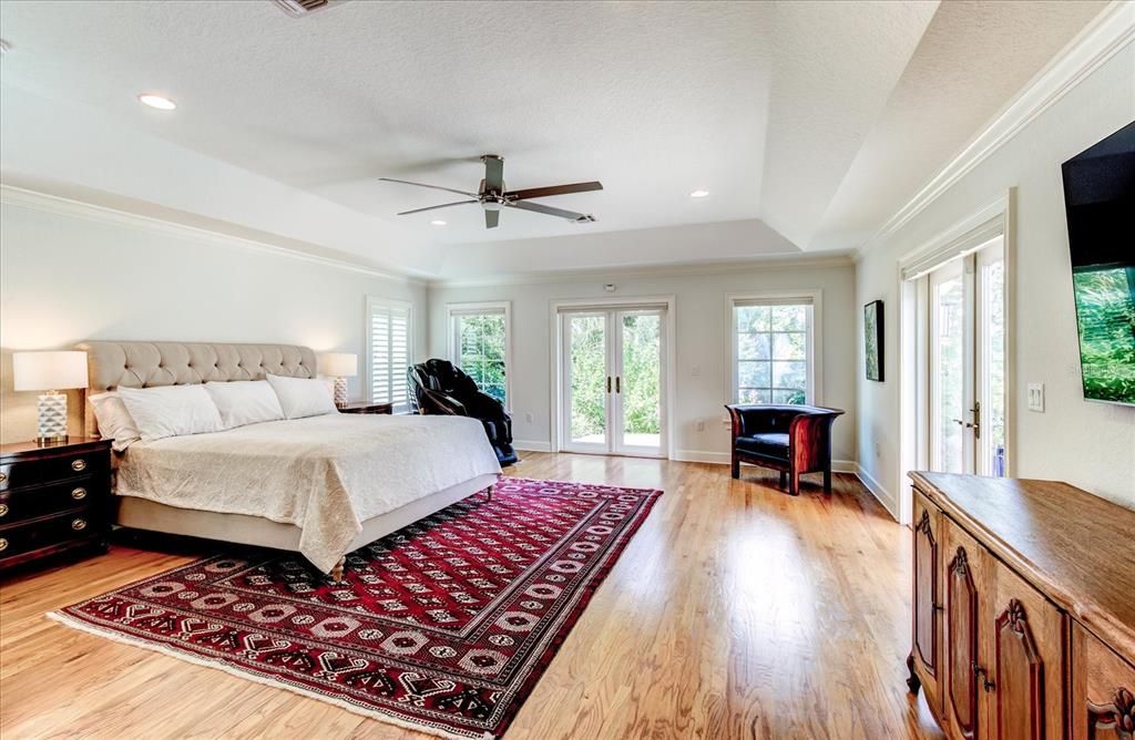 Master bedroom with French doors leading to lake and pool area.