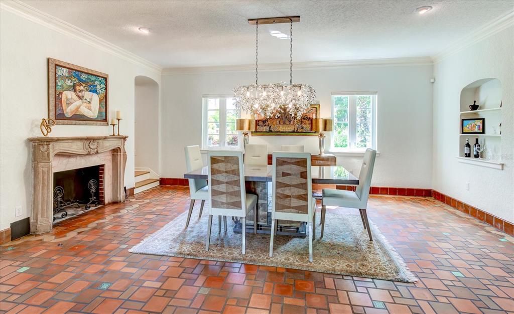 Large dining room area with fireplace and original tile flooring.