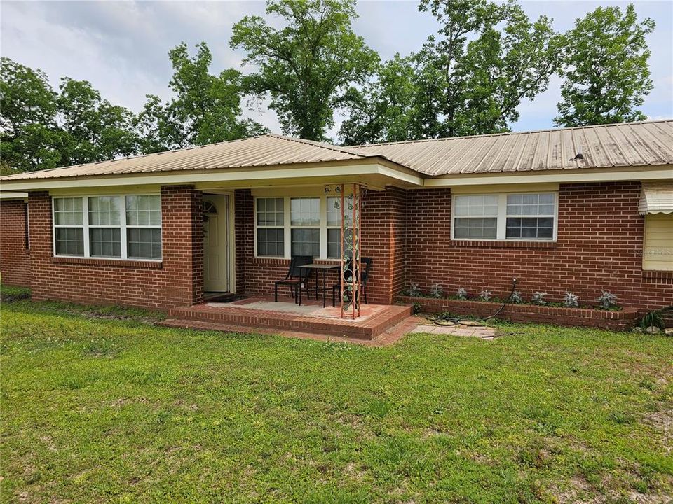 3 bedroom 2 bath ranch style brick home with a metal roof.