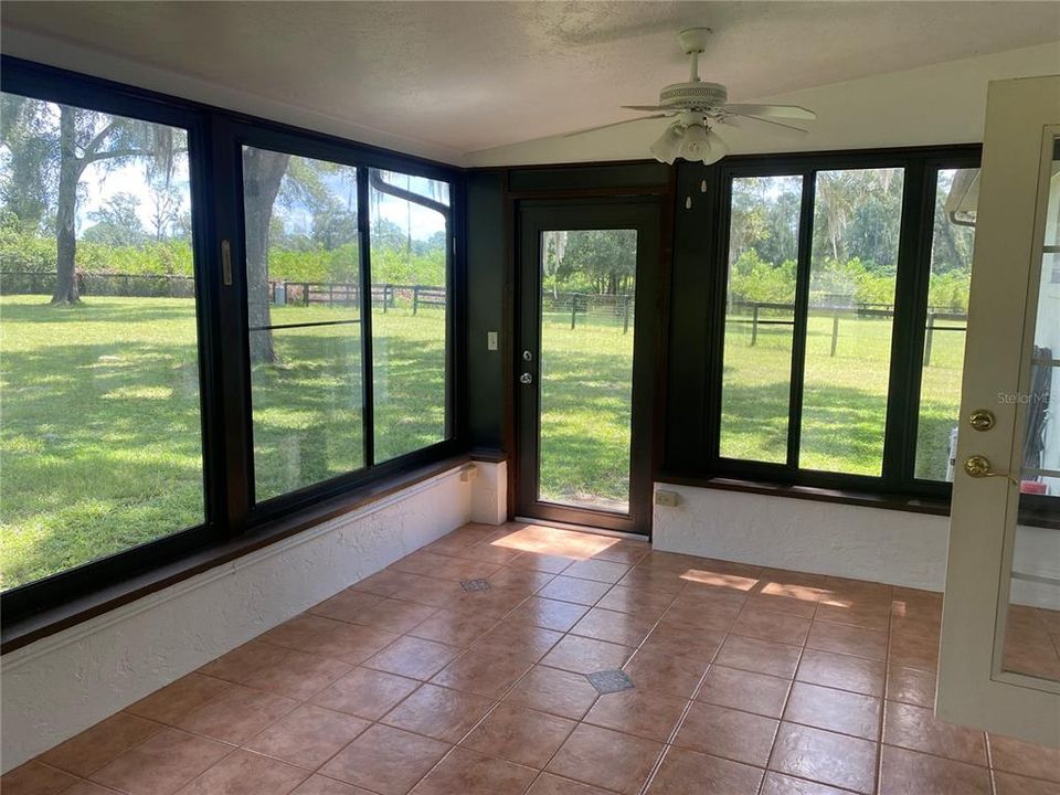 Large, enclosed sunroom with tiled floor