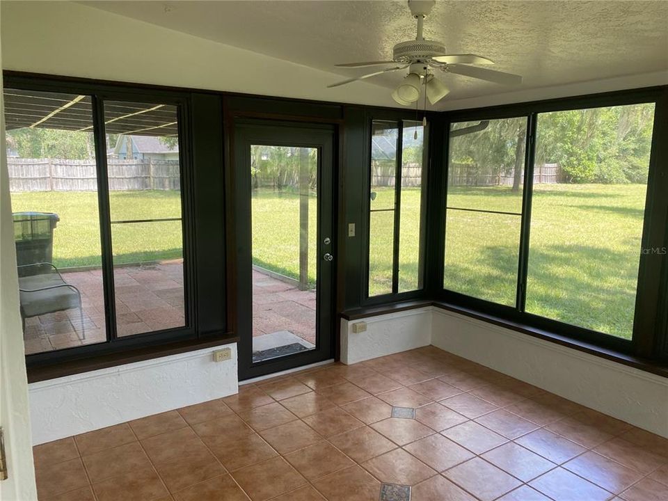 Large, enclosed sunroom with tiled floor