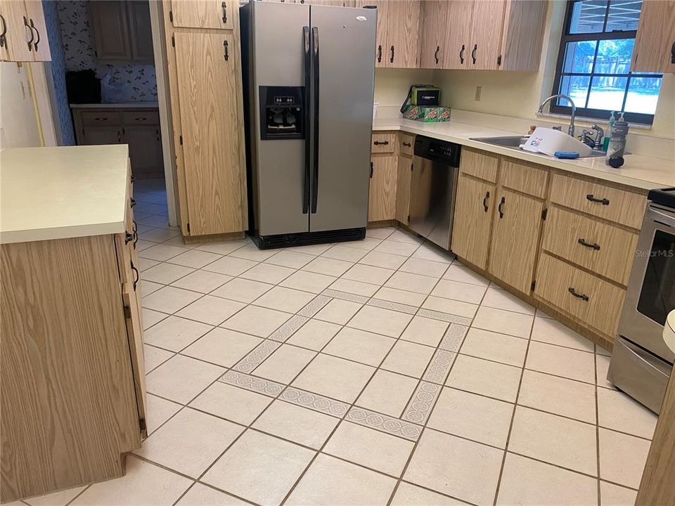 Kitchen with tiled floor and newer SS appliances