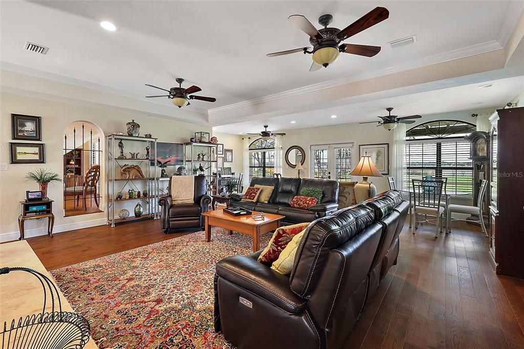 Family room has ample seating areas, and French doors overlooking the back view of Lake Dora