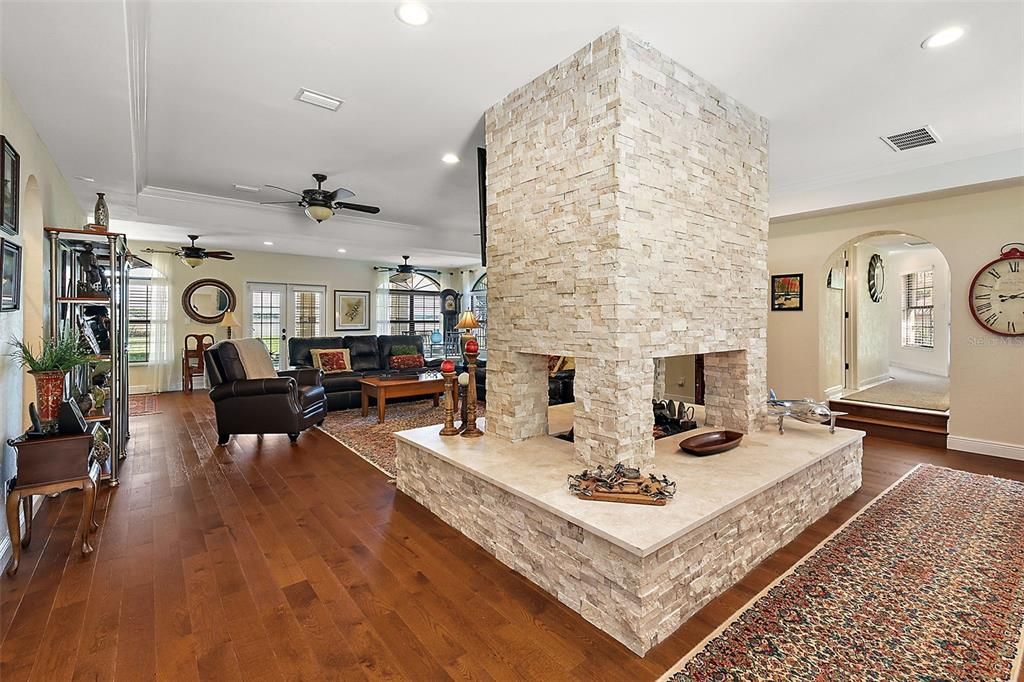 The stone-stacked gas fireplace divides the living space, adding to the room's elegant and cozy feel