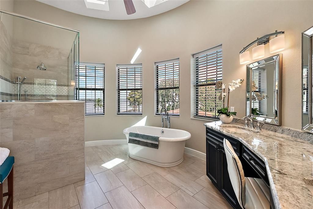 Primary Owner's en-suite bath with 4 skylights and a wall of windows that overlook Lake Dora