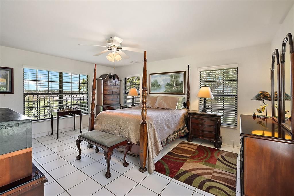 Main level secondary owner's suite (bedroom 2) with tile flooring and views of Lake Dora