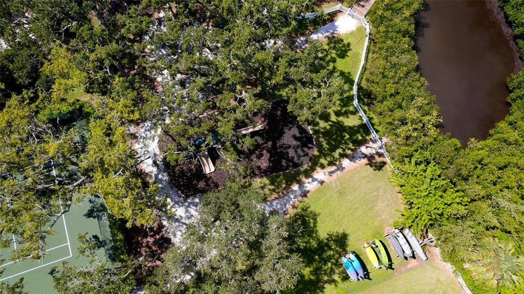 Bird's eye view of the tennis courts, playground, kayak storage and bridge entrance to the jogging trail.