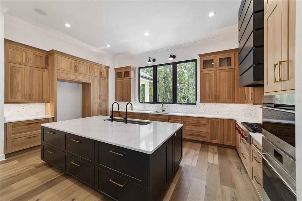 CUSTOM WOOD CABINETS WITH CUSTOM STORAGE FEATURES AND AN ABUNDANCE OF DEEP DRAWERS