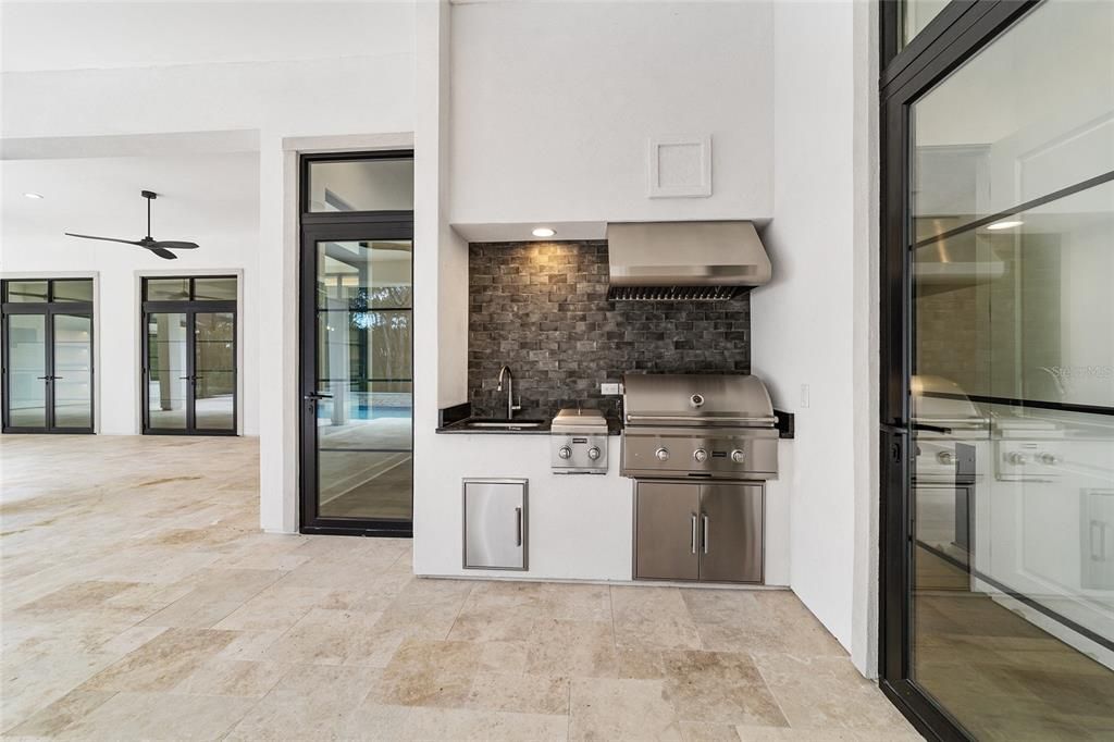 SUMMER KITCHEN AREA WITH COYOTE GRILL, ADJACENT GAS BURNERS, AND SINK