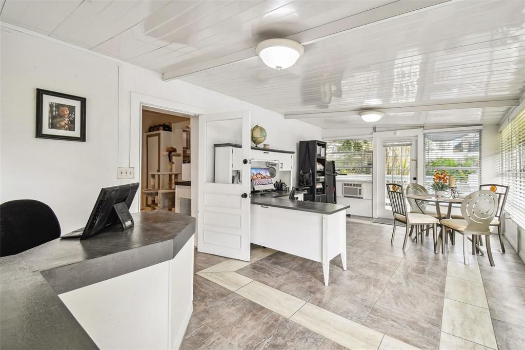 Sunroom being utilized as a large office area